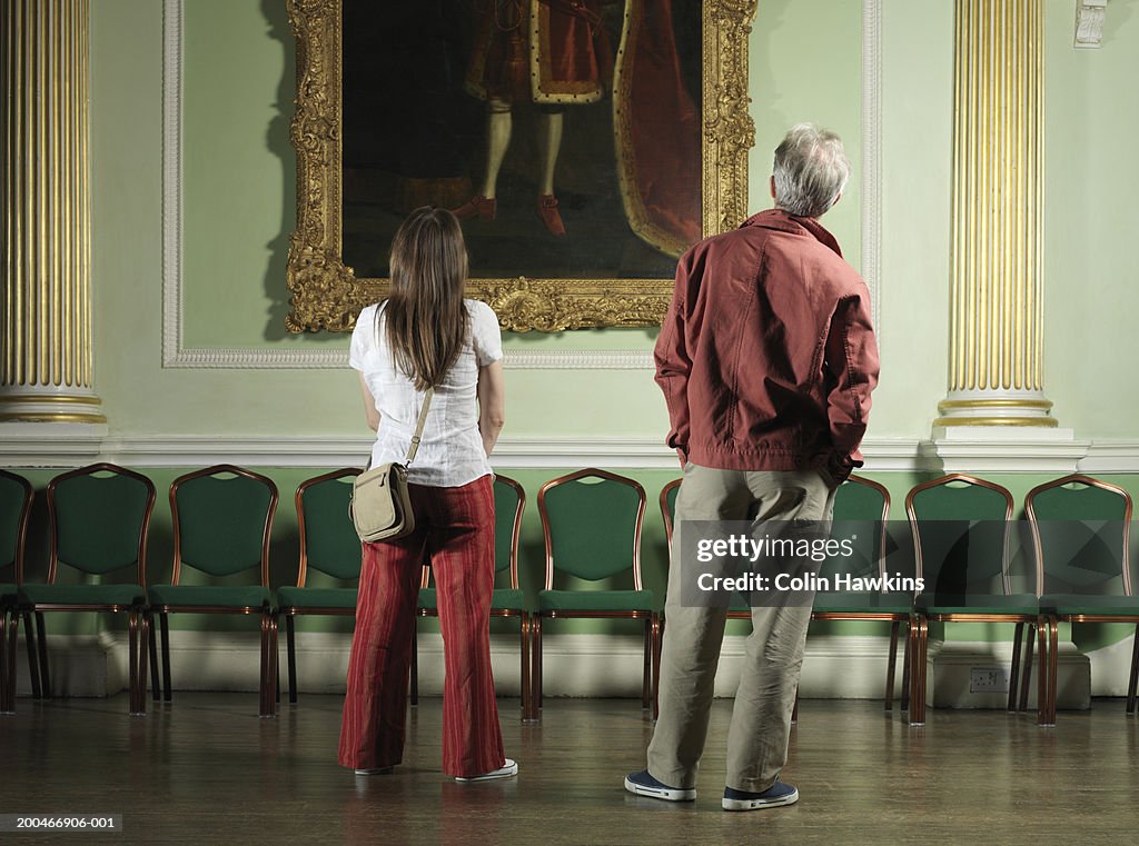 England, Bath, mature couple looking at painting, rear view