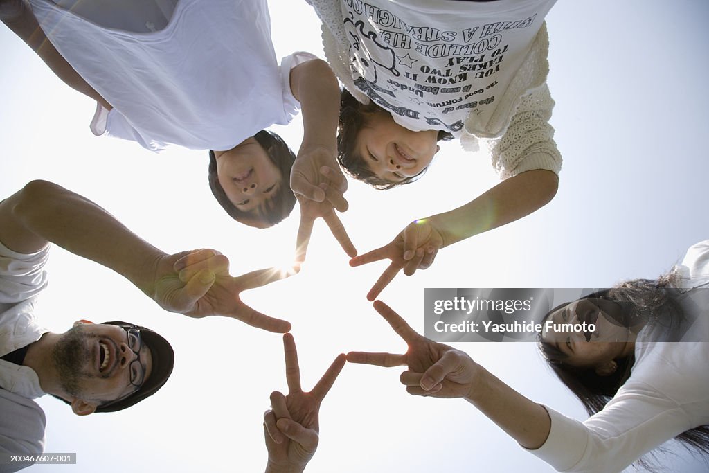 Parents and two children (8-10) standing in circle, view from below