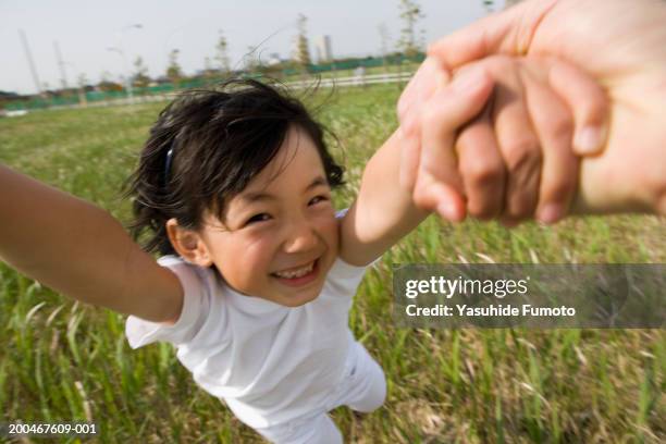 father holding daughter's (7-9) hands, spinning in circles - children swinging stock pictures, royalty-free photos & images