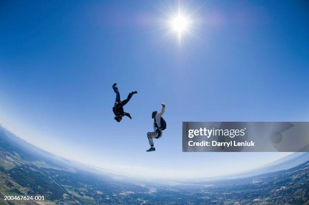 two skydivers freefalling, side view - two skydivers stock pictures, royalty-free photos & images