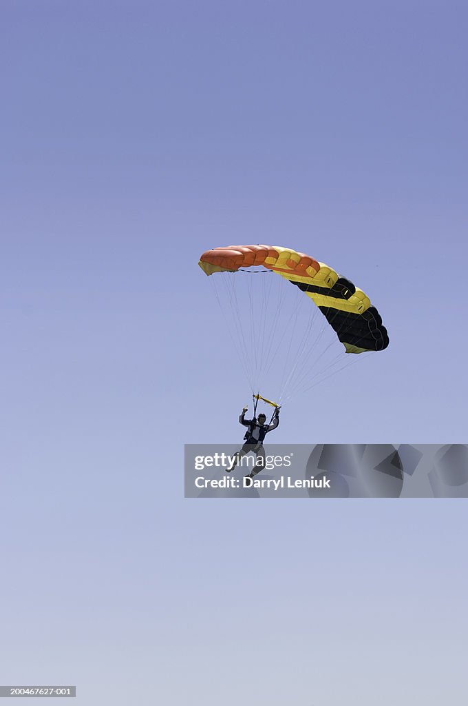 Young man parachuting, aerial view