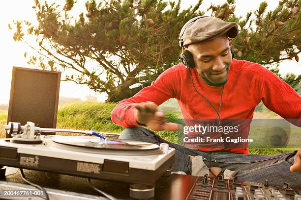 young male dj spinning records on lawn in park, sunset - berkeley foto e immagini stock