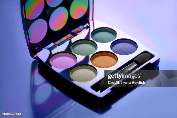 beauty cosmetic product for a woman makeup eyeshadow on dark lavender purple violet color background. concept of color trend 2024 peach color. - paleta de maquilhagem imagens e fotografias de stock