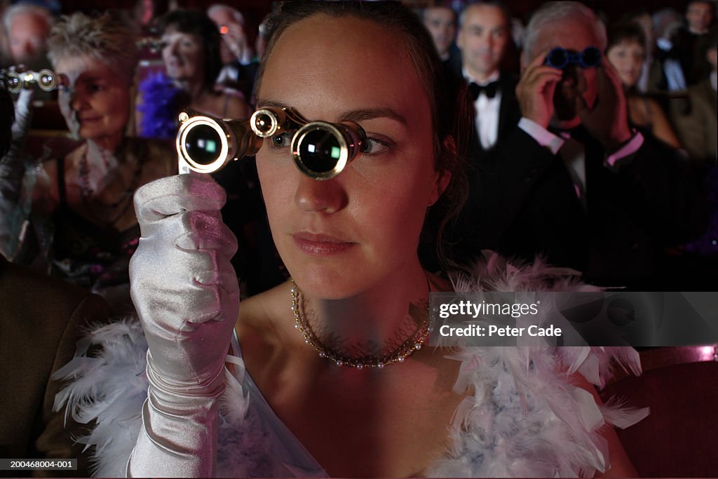 Woman in audience using opera glasses