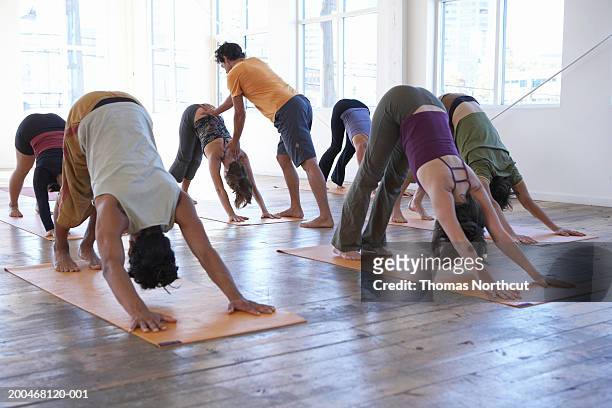 male yoga instructor teaching class of six adults - yoga studio stock pictures, royalty-free photos & images