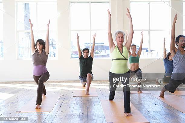 six adults practicing yoga, arms raised - senior adult yoga stock pictures, royalty-free photos & images
