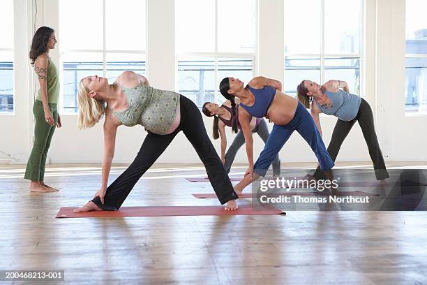 yoga instructor teaching four pregnant women in yoga class - leggings imagens e fotografias de stock