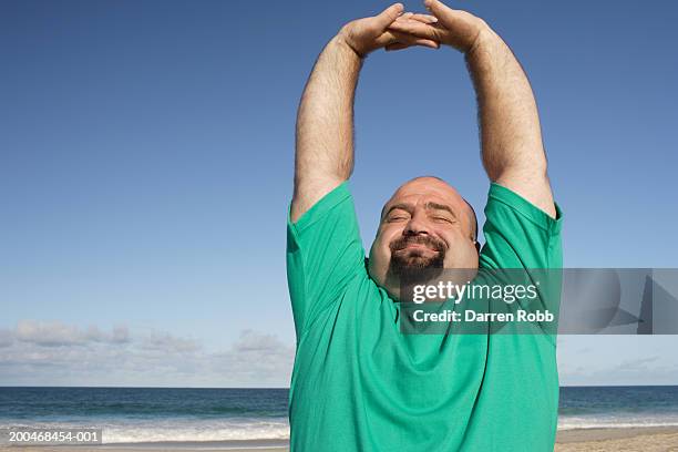 man stretching on beach, close-up - body positive stockfoto's en -beelden