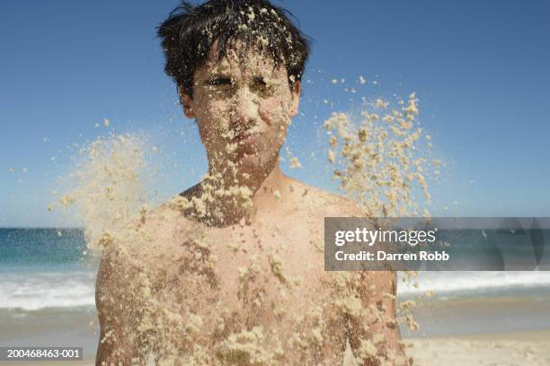 young man being covered in sand, close-up - head in sand stock-fotos und bilder