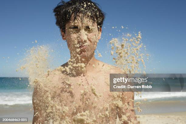 young man being covered in sand, close-up - avvolto foto e immagini stock
