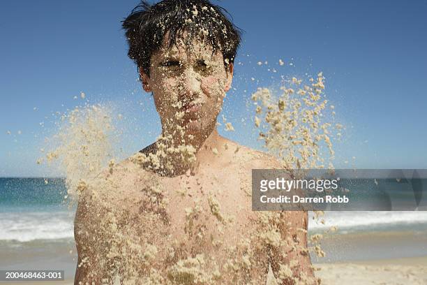 young man being covered in sand, close-up - hurl stock pictures, royalty-free photos & images
