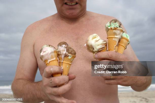 man holding melting ice creams, mid section, close-up - 5 funny stockfoto's en -beelden