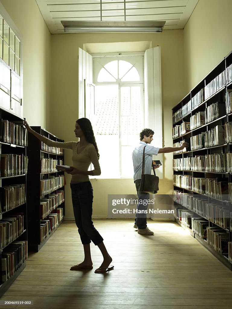 Teenage students (15-17) browsing in library, side view