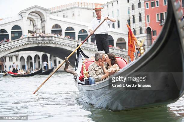 italy, venice, couple riding gondola, kissing - venice italy stock pictures, royalty-free photos & images
