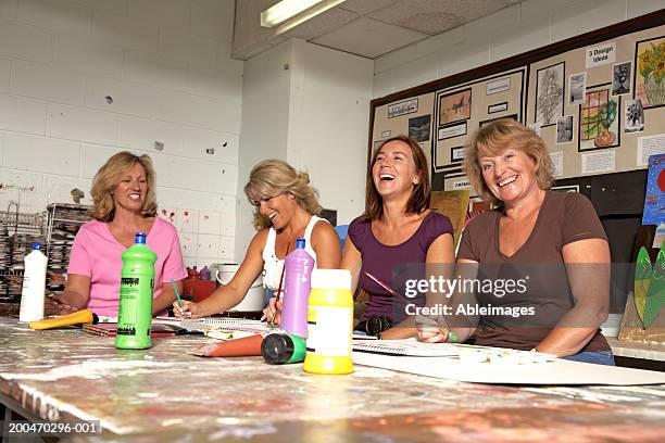 mature women painting in art classroom, laughing - art and craft stock pictures, royalty-free photos & images