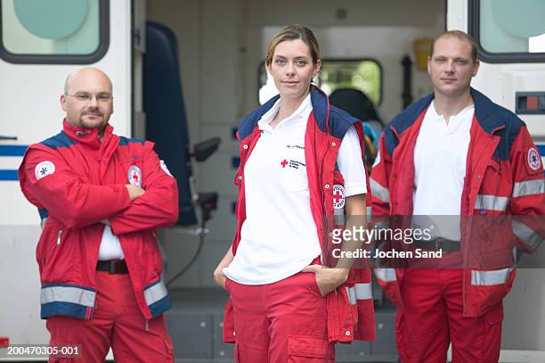 "three paramedics standing beside ambulance, portrait" - paramedics stock-fotos und bilder