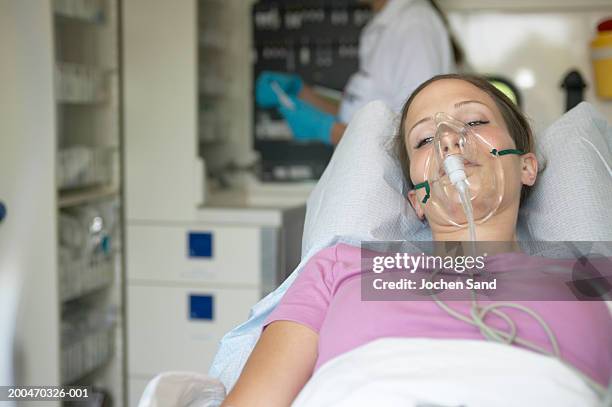 "female patient in ambulance, wearing oxygen mask, eyes open" - oxygen mask stock-fotos und bilder