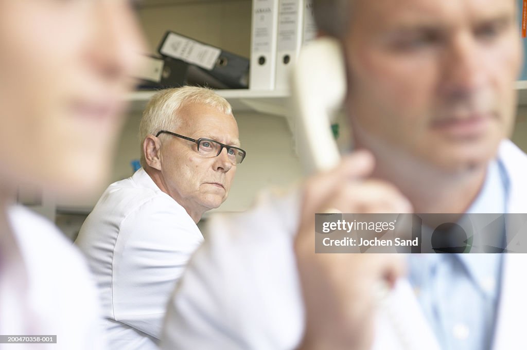 Three doctors, focus on male doctor in background