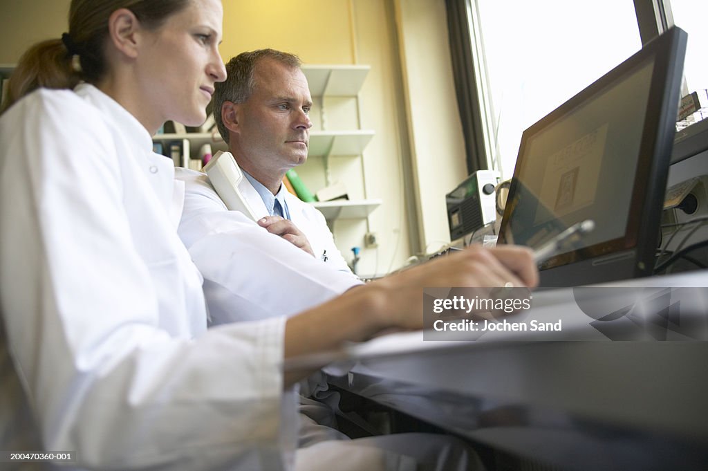 Two doctors looking at computer screen, low angle view