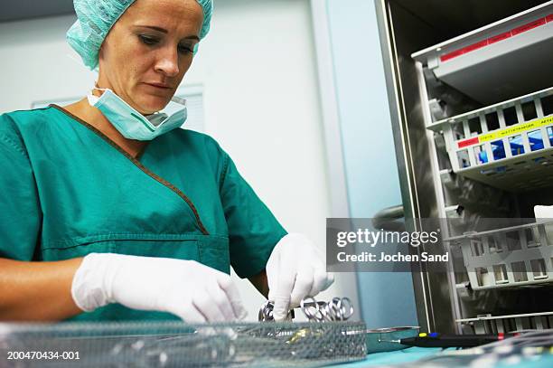 female operating theatre staff wearing scrubs, preparing instruments - equipamento cirúrgico imagens e fotografias de stock
