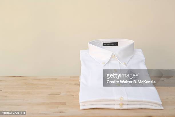 stacks of white shirts - shirt no people foto e immagini stock
