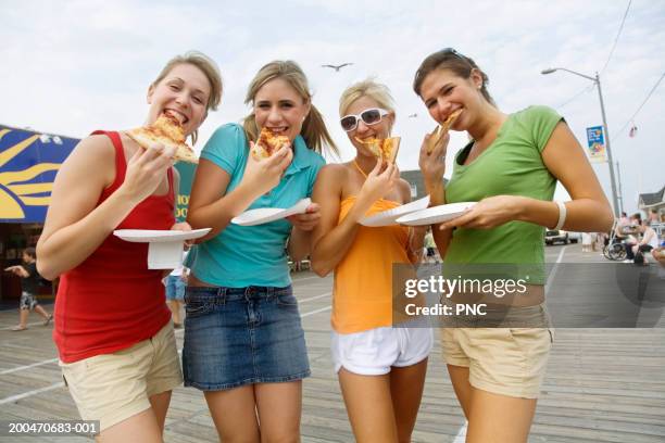 four teenage girls (16-18) eating pizza on boardwalk, portrait - ocean city imagens e fotografias de stock