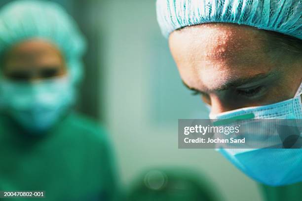 "operating theatre team at work, surgeons with sweaty brow, close-up" - effort imagens e fotografias de stock