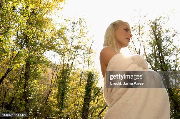 young woman in woods, wrapped in towel, low angle view - 0703ef stock pictures, royalty-free photos & images