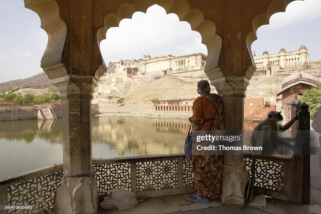 India, Rajasthan, woman standing on veranda, Amber Fort in distance