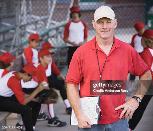 coach and boys (9-11) in baseball dugout (focus on coach) - coach clipboard stock pictures, royalty-free photos & images