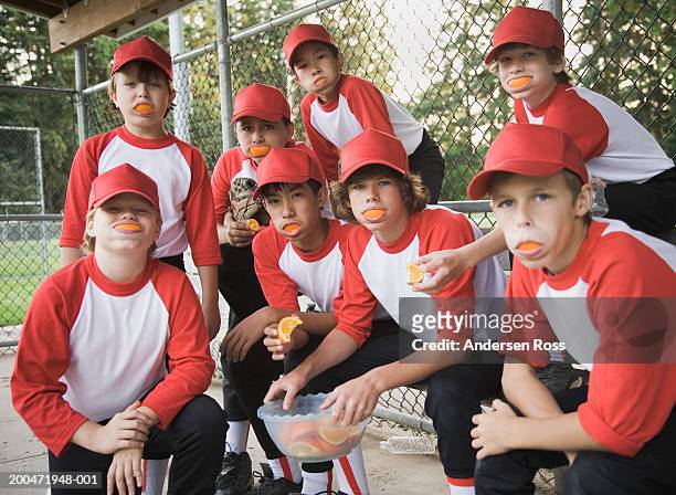 baseball players (7-14) with orange slices in their mouths, portrait - 棒球隊 個照片及圖片檔