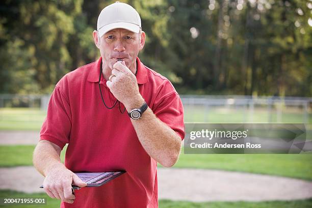 coach blowing whistle on baseball field, portrait - coach clipboard stock pictures, royalty-free photos & images