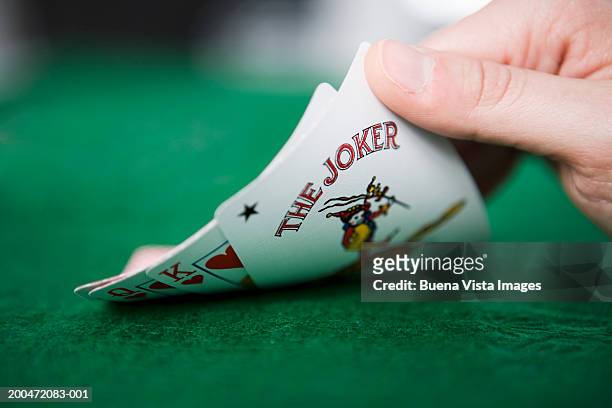woman playing cards, looking at hand, close-up - wild card stock pictures, royalty-free photos & images