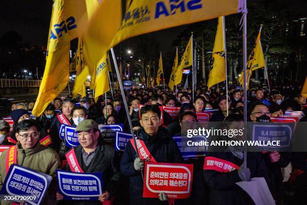 Doctors hold placards that read 'Opposition to the increase in medical schools' as they gather to protest against the government's plan to raise the...