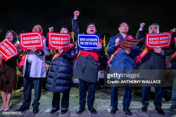 Doctors hold placards that read 'Opposition to the increase in medical schools' as they gather to protest against the government's plan to raise the...