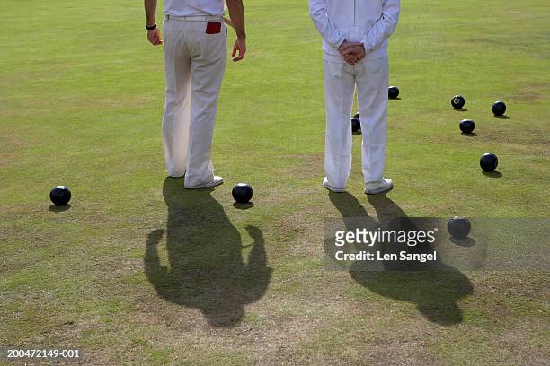 two men standing on bowling green, rear view, low section - lawn bowls stock pictures, royalty-free photos & images