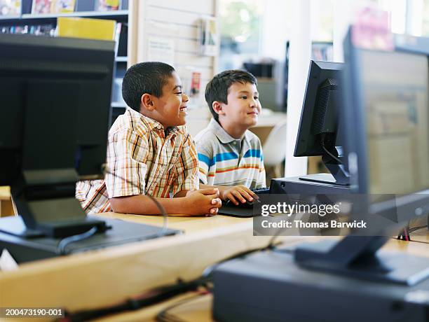 Two Boys Using Computer In Library Smiling High-Res Stock Photo - Getty ...