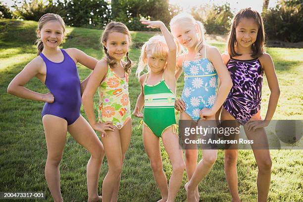 five girls (7-10) in swimsuits standing side by side, portrait - young girl swimsuit stockfoto's en -beelden
