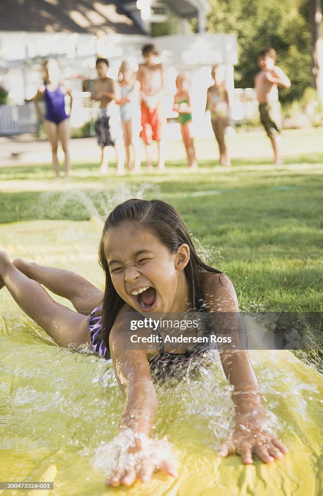 Girl Sliding Down Water Slide On Lawn High-Res Stock Photo - Getty Images