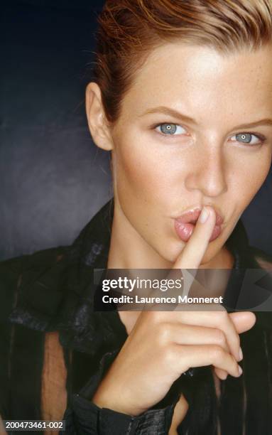 young woman with finger to mouth, close-up, portrait - woman hush stock pictures, royalty-free photos & images