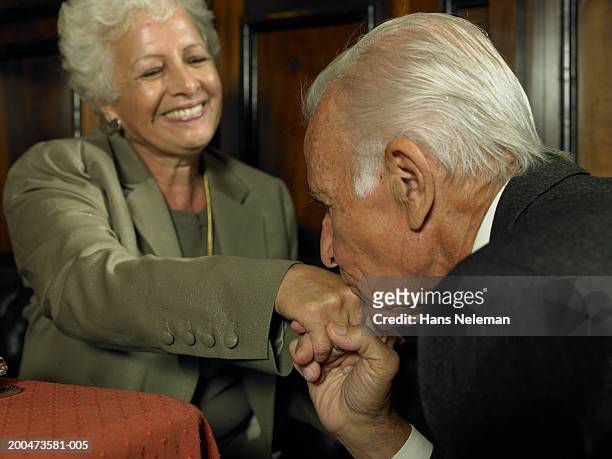 senior man kissing woman's hand in restaurant - kyssa på handen bildbanksfoton och bilder
