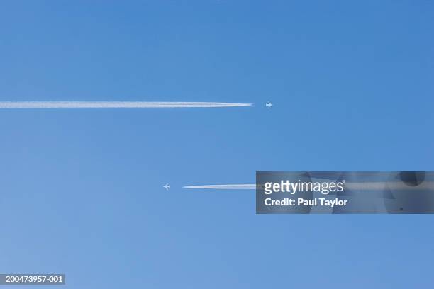 jets vapour trails flying past each other (digital enhancement) - gå vidare bildbanksfoton och bilder