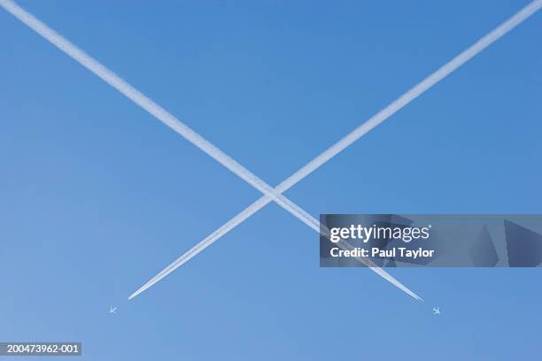 jets vapour trails making x mark (digital enhancement) - x marks the spot - fotografias e filmes do acervo