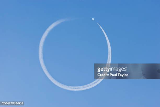 jet vapour trail making circle in sky (digital enhancement) - rastro de avião - fotografias e filmes do acervo