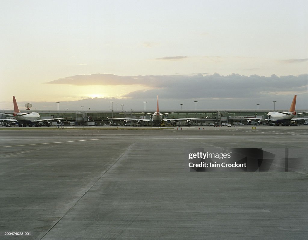 England, London, three planes waiting at Heathrow airport, dusk