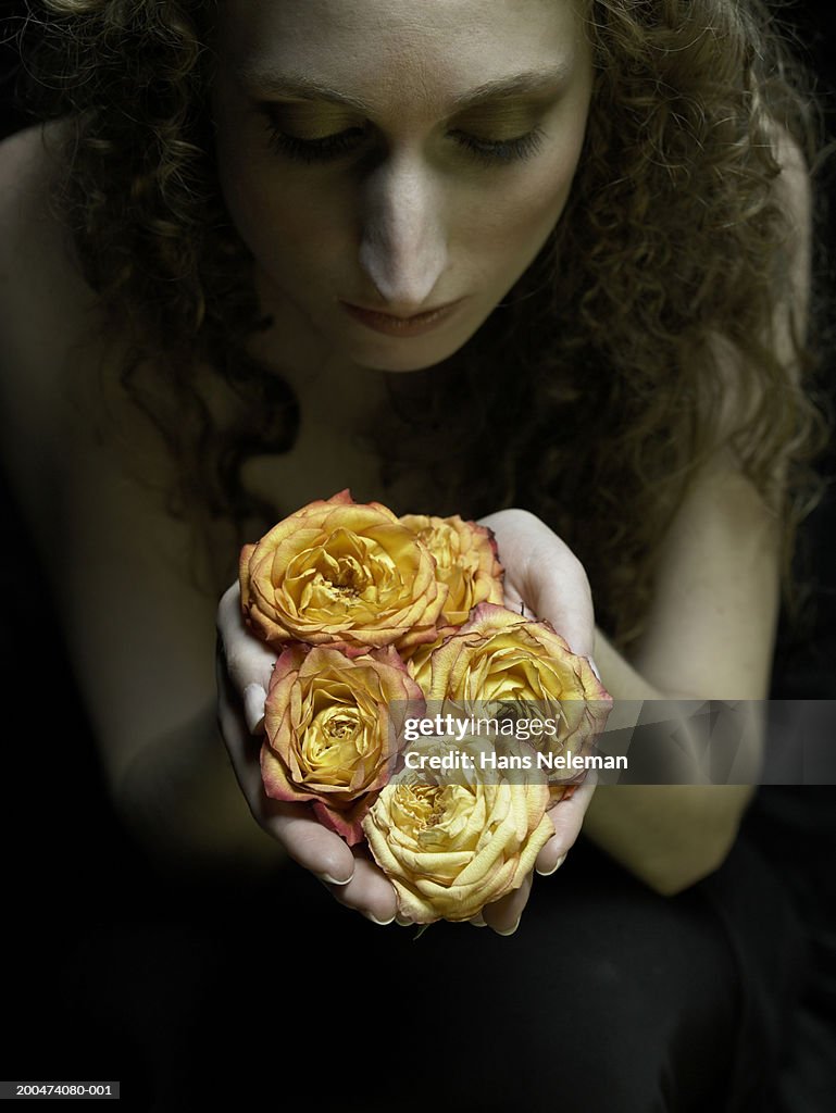 Young woman kneeling, holding flowers