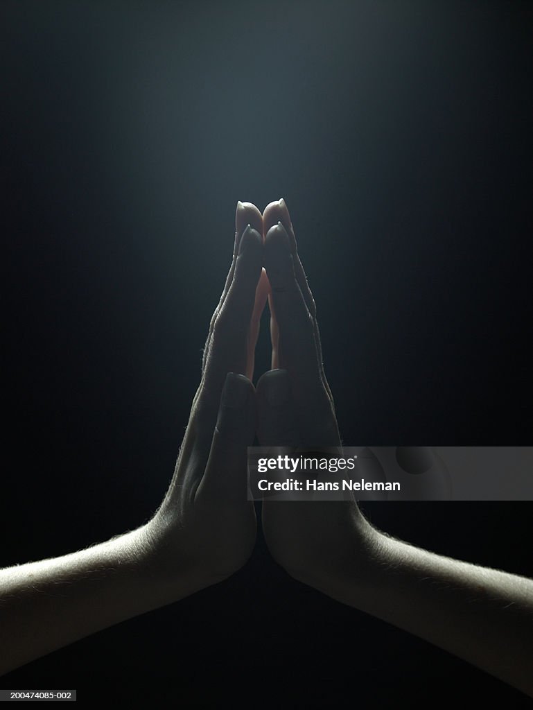 Woman pressing palms together, close-up