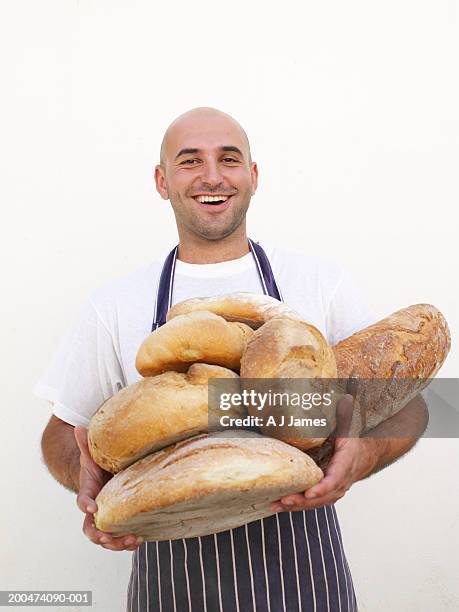 man holding bread, smiling, portrait - baker stock pictures, royalty-free photos & images