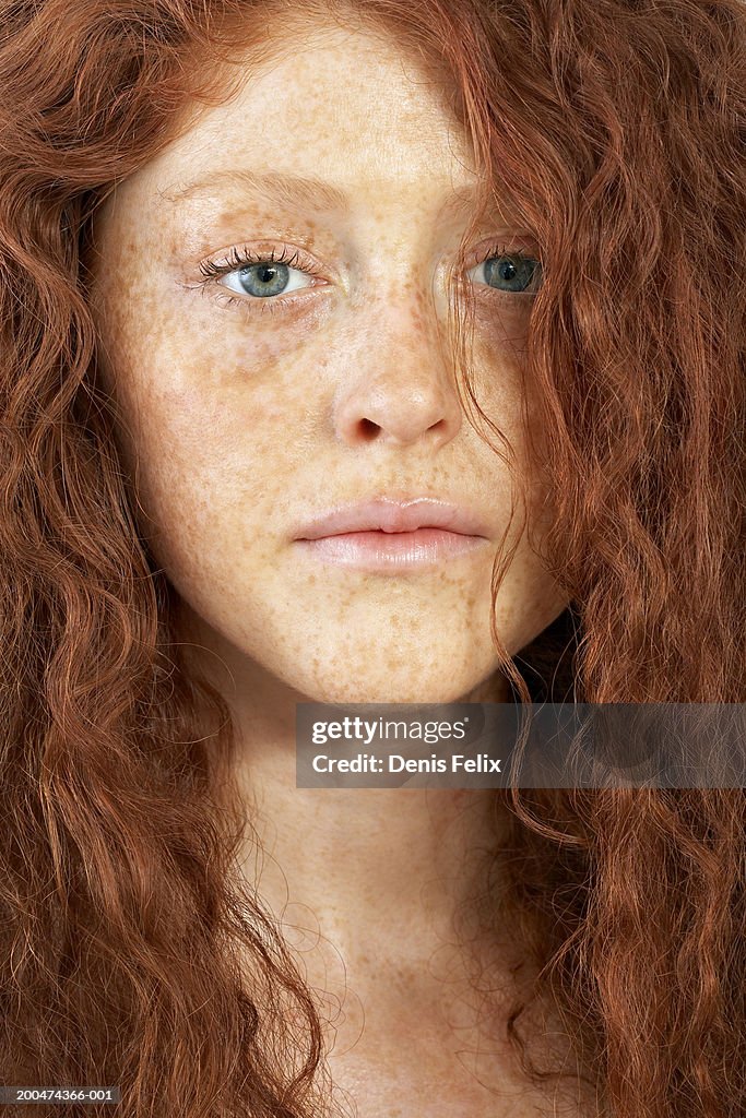 Young woman with curly hair and freckles, portrait, close-up