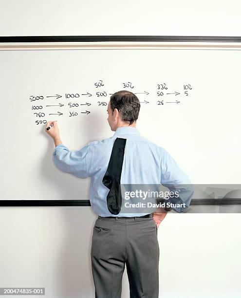 man with sock stuck on back of shirt writing on whiteboard, rear view - sock stock pictures, royalty-free photos & images
